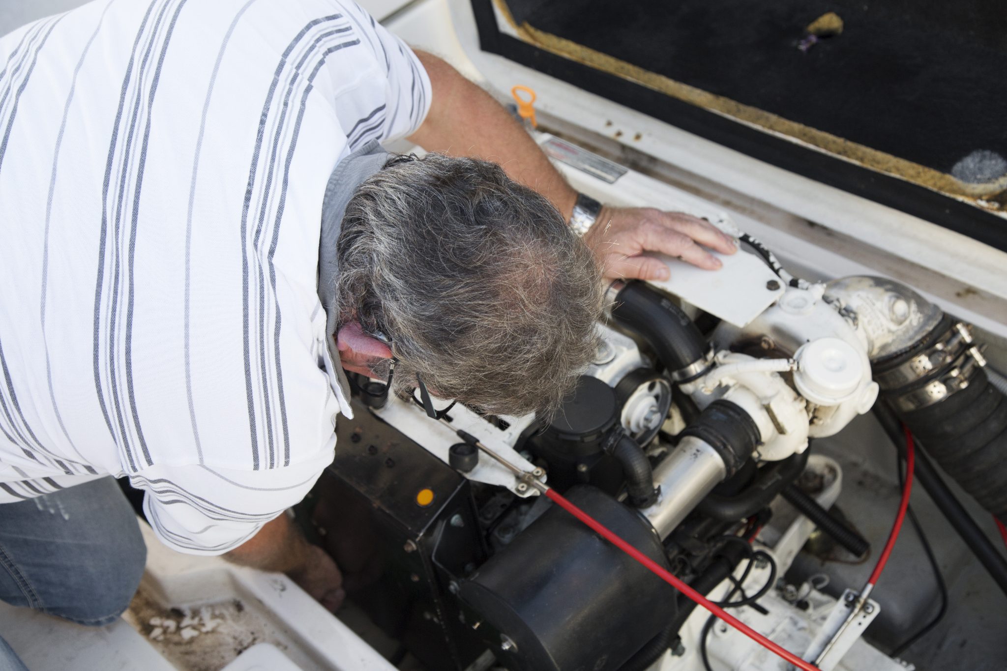 closeup of a man repairing a boat engine Seaworthy Inspections